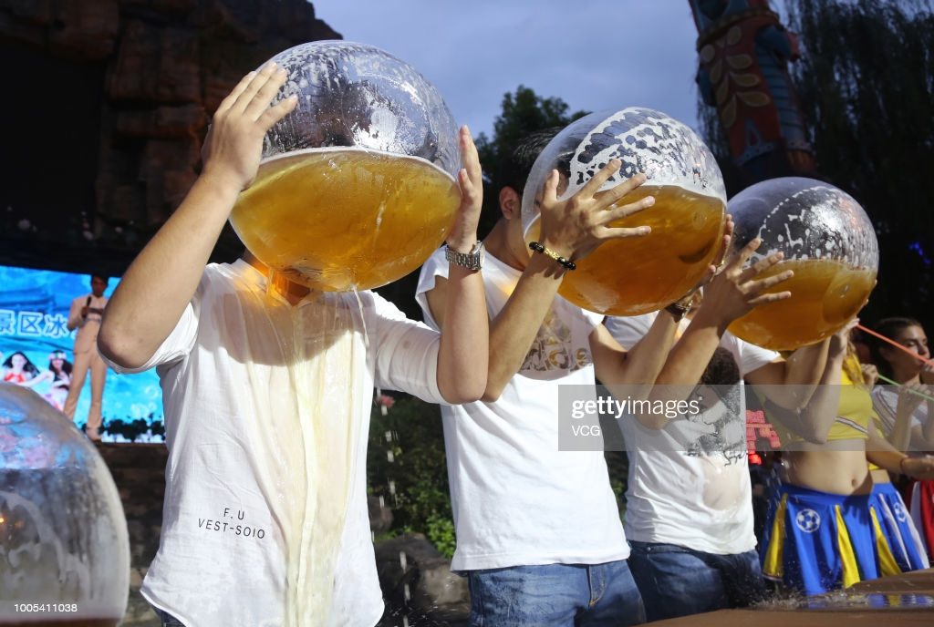 tourists-drink-beer-with-fishbowls-during-a-beer-drinking-competition-picture-id1005411038
