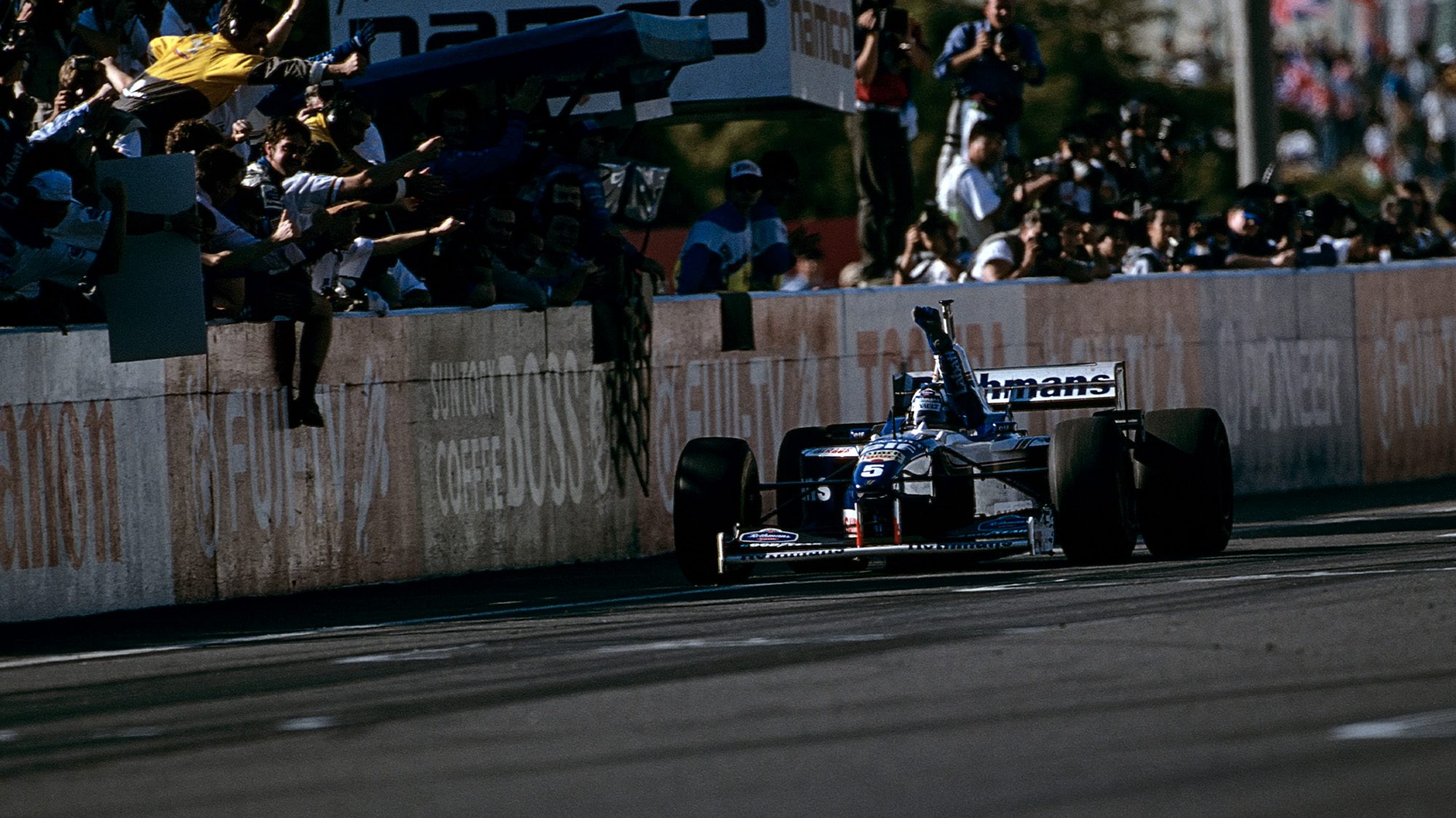 Damon-Hill-crosses-the-finish-line-at-the-1996-Japanese-Grand-Prix-at-Suzuka-to-claim-the-Formula-1-Drivers-Wold-Championship.jpg