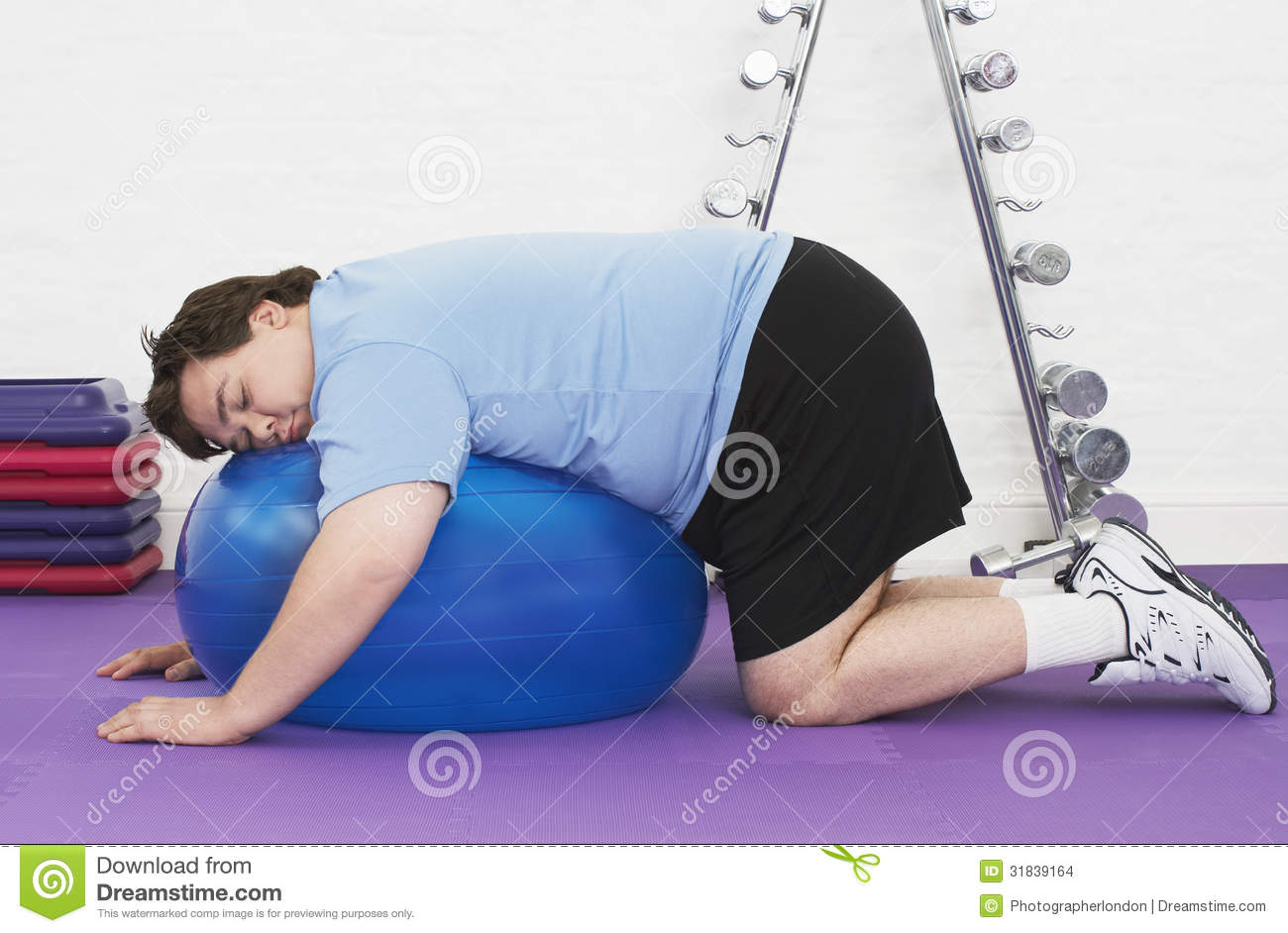 overweight-man-sleeping-exercise-ball-side-view-health-club-31839164.jpg