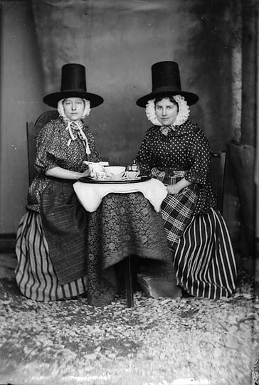 Two_women_in_national_dress_drinking_tea_%28Jones%29_NLW3363089.jpg