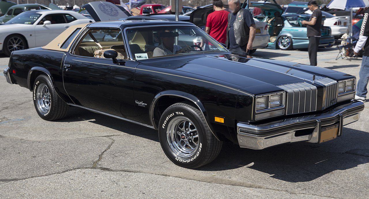 1280px-1977_Oldsmobile_Cutlass_Supreme_Brougham_coupe_at_Belmont%2C_front_right.jpg